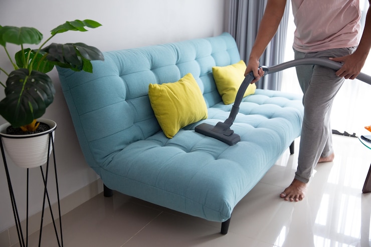 a person vacuuming a couch to clean in corvallis for Upholstery Cleaning